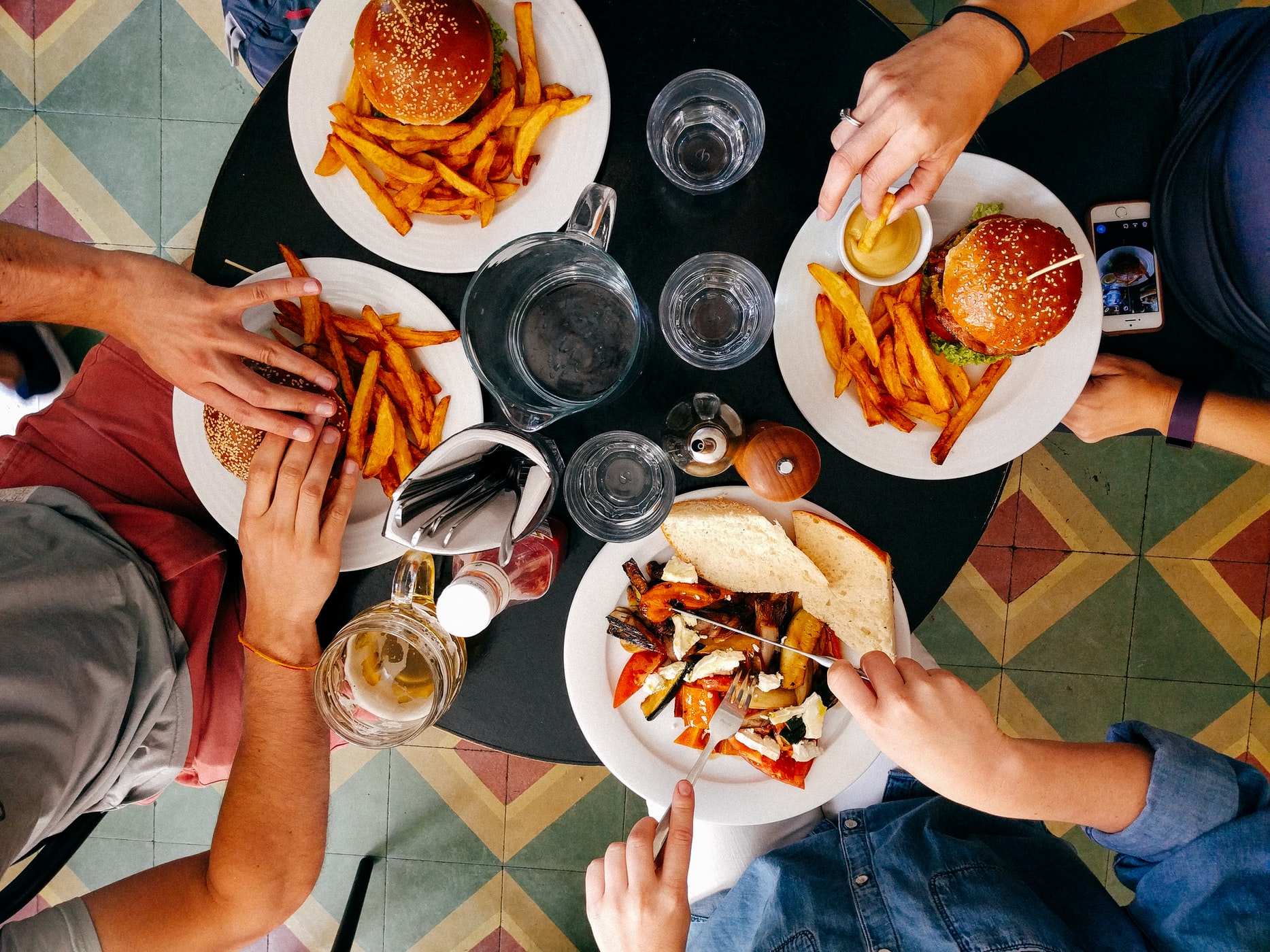 Group of Four Friends Eating Food at a Restaurant